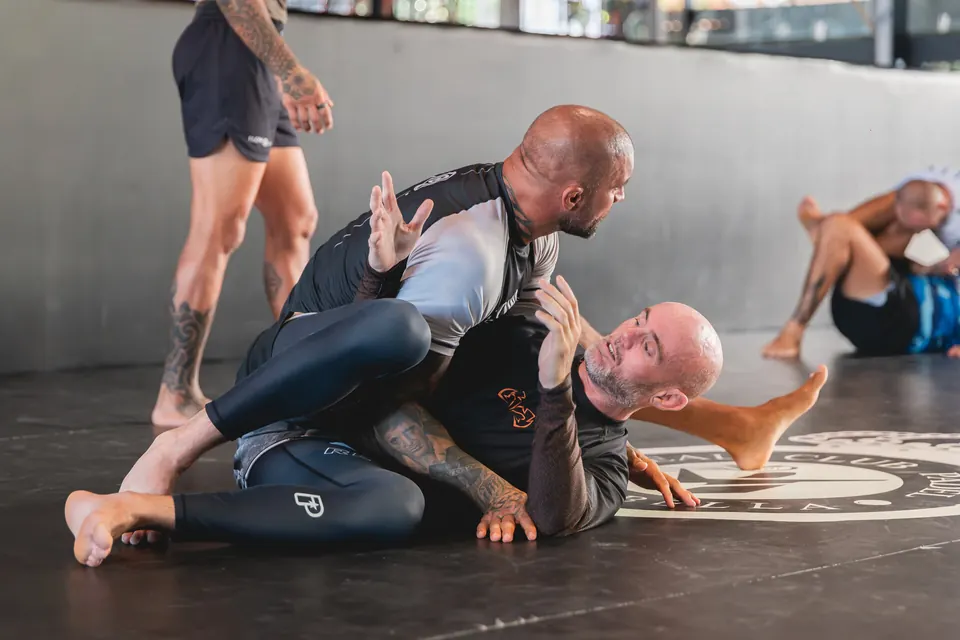 Students practising Brazilian Jiu-Jitsu on the mat.