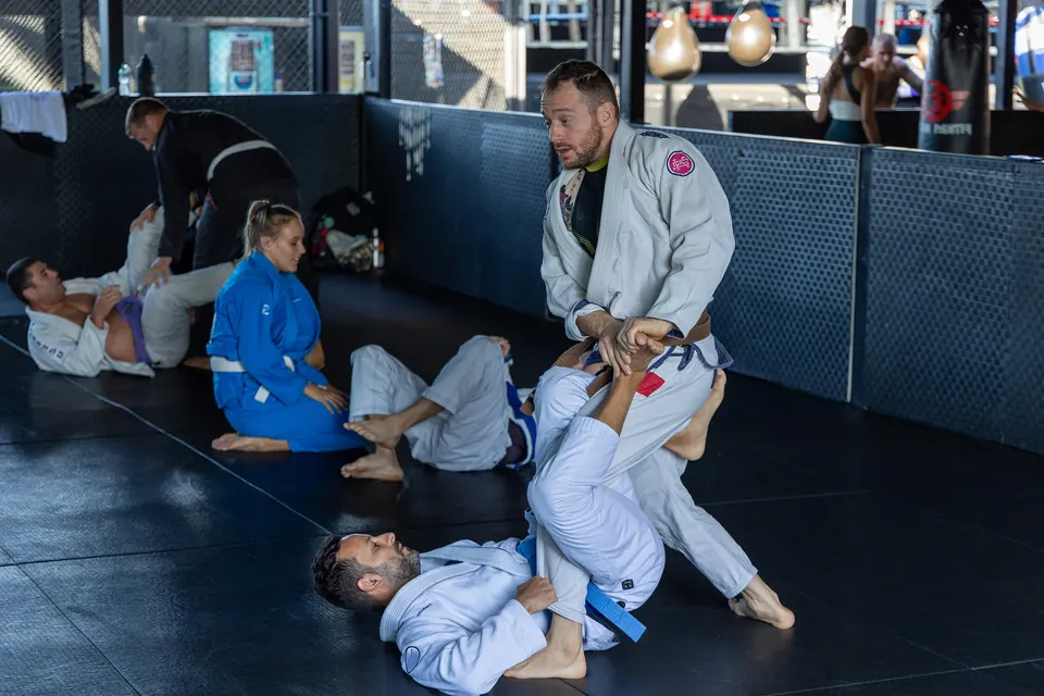 Coach guiding a student through a Jiu-Jitsu technique at Real Padel Club